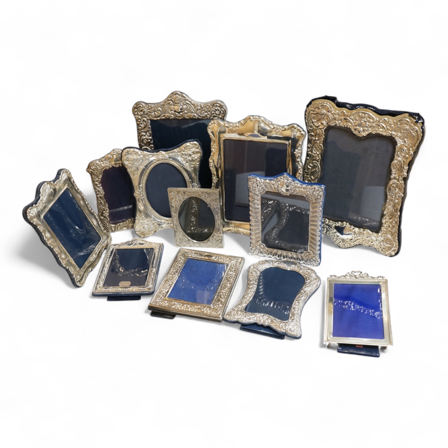 A George V silver mounted rectangular photograph frame, with ribbon bow crest, by Stokes & Ireland Ltd, Chester, 1912, 18.2cm including crest, together with ten other modern silver mounted photograph frames, largest 29.4